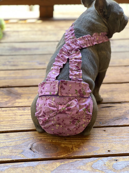 Bulldog wearing a purple floral diaper with bow
